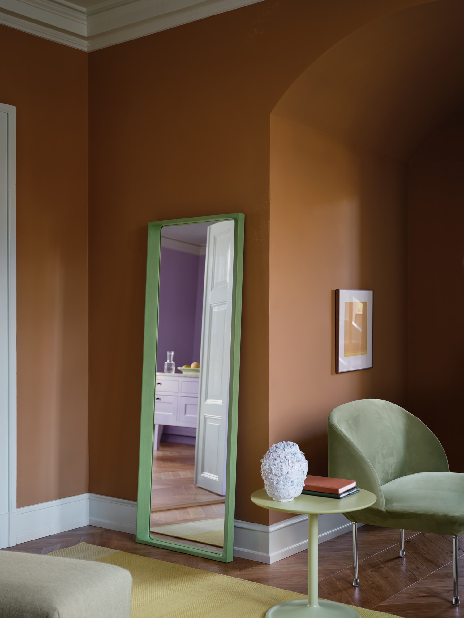 Interior setting featuring the Arced Mirror in light green, Soft Side Table in beige green, Varjo Rug in yellow, and Oslo 1-Seater upholstered in Allure Leather with chrome legs. Interior setting featuring the Arced Mirror in light green, Soft Side Table in beige green, Varjo Rug in yellow, and Oslo 1-Seater upholstered in Allure Leather with chrome legs.