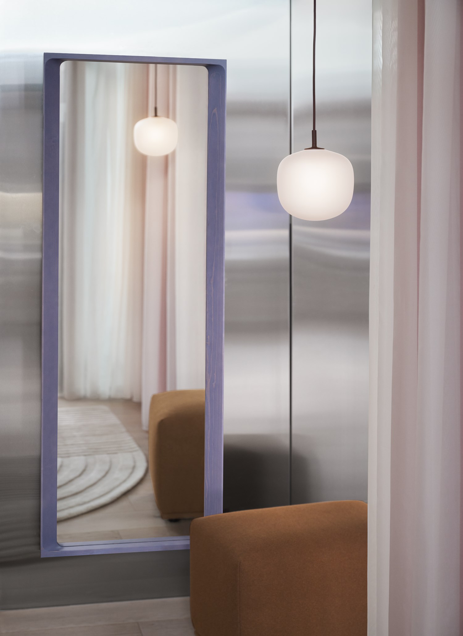 Arced mirror in light lilac, with Ecco Pouf and Relevo Rug in the color off-white. Rhime lamp in the color black. Arced mirror in light lilac, with Ecco Pouf and Relevo Rug in the color off-white. Rhime lamp in the color black.