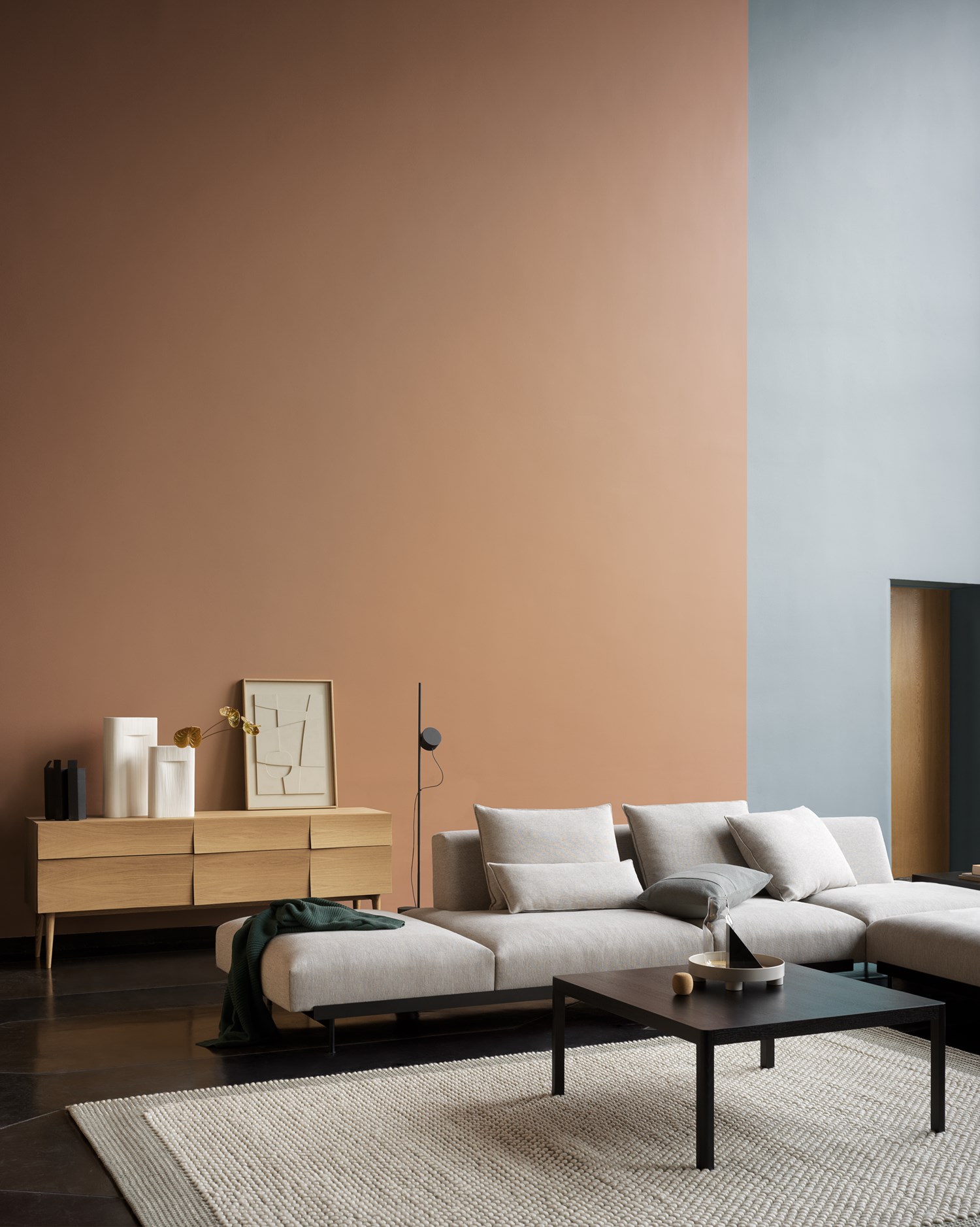 Living room setting featuring the In Situ corner sofa configuration in Clay 12, Workshop Coffee Table in black, Pebble Rug in light grey, and Reflect Sideboard in oak. Living room setting featuring the In Situ corner sofa configuration in Clay 12, Workshop Coffee Table in black, Pebble Rug in light grey, and Reflect Sideboard in oak.