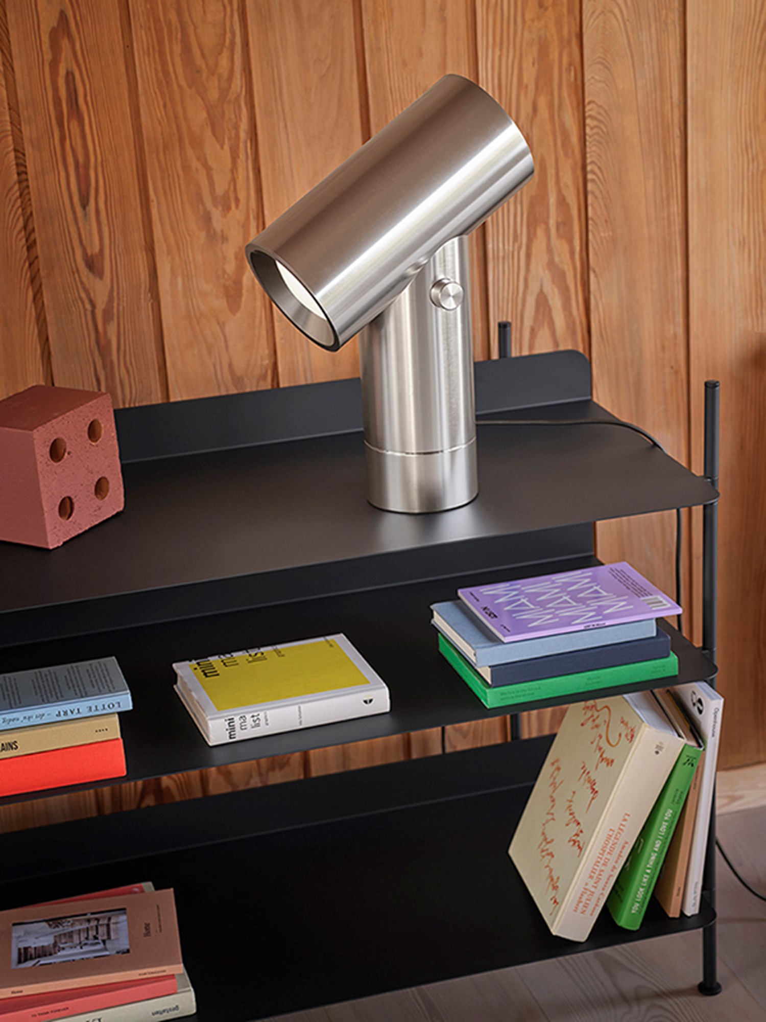 A polished aluminum lamp standing on a black compile shelving system. This 45 cm beam lamp offers a striking visual balance, perfect for enhancing contemporary workspaces or living areas. A polished aluminum lamp standing on a black compile shelving system. This 45 cm beam lamp offers a striking visual balance, perfect for enhancing contemporary workspaces or living areas.