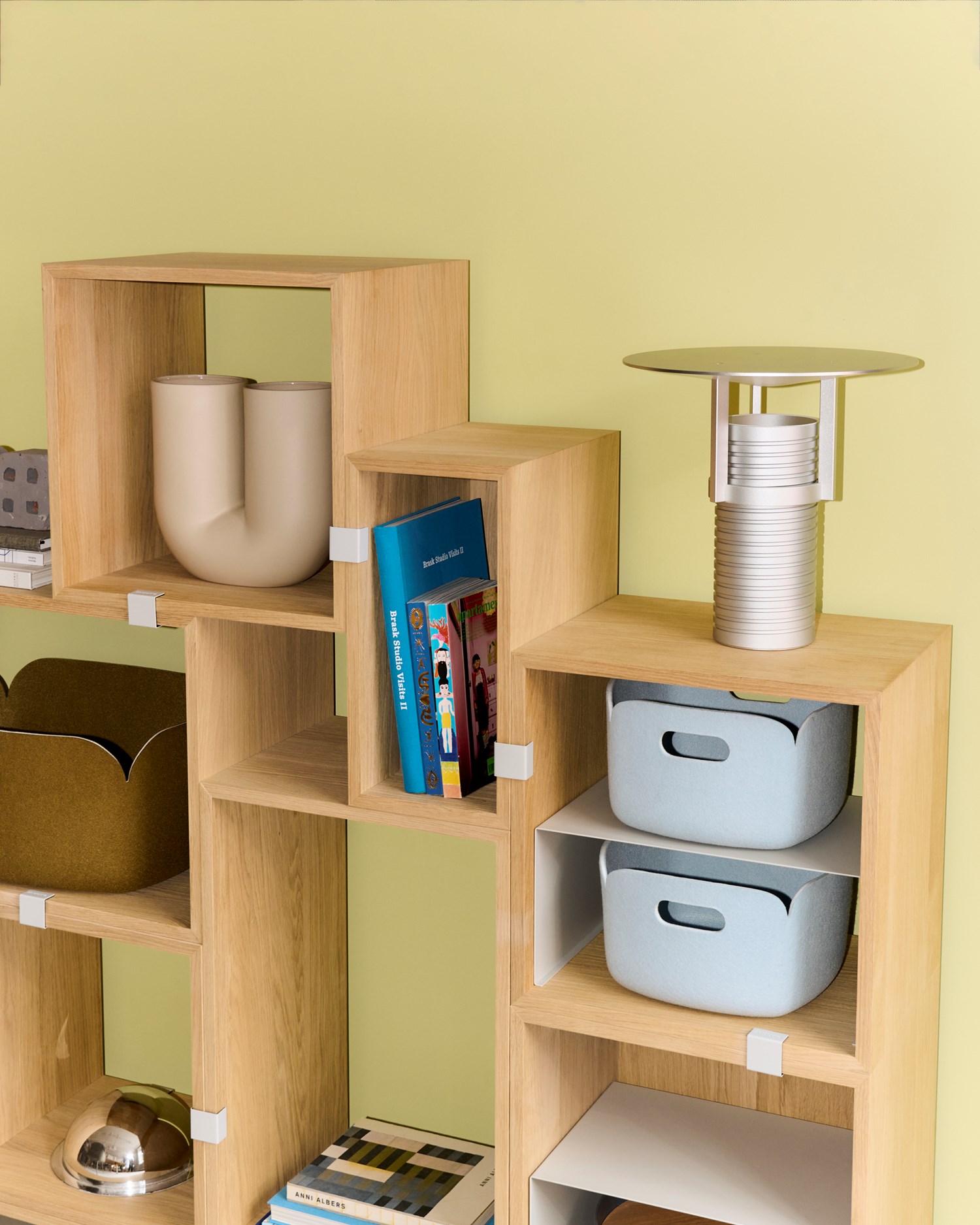 Image of the Muuto Restore Basket in Light Blue. The basket is part of a set placed on Stacked Bookcase in oak. A modern table lamp with a soft, rounded design complements the arrangement, creating a harmonious, minimalist aesthetic. The basket's recycled felt material adds a sustainable and functional element to the scene. Image of the Muuto Restore Basket in Light Blue. The basket is part of a set placed on Stacked Bookcase in oak. A modern table lamp with a soft, rounded design complements the arrangement, creating a harmonious, minimalist aesthetic. The basket's recycled felt material adds a sustainable and functional element to the scene.