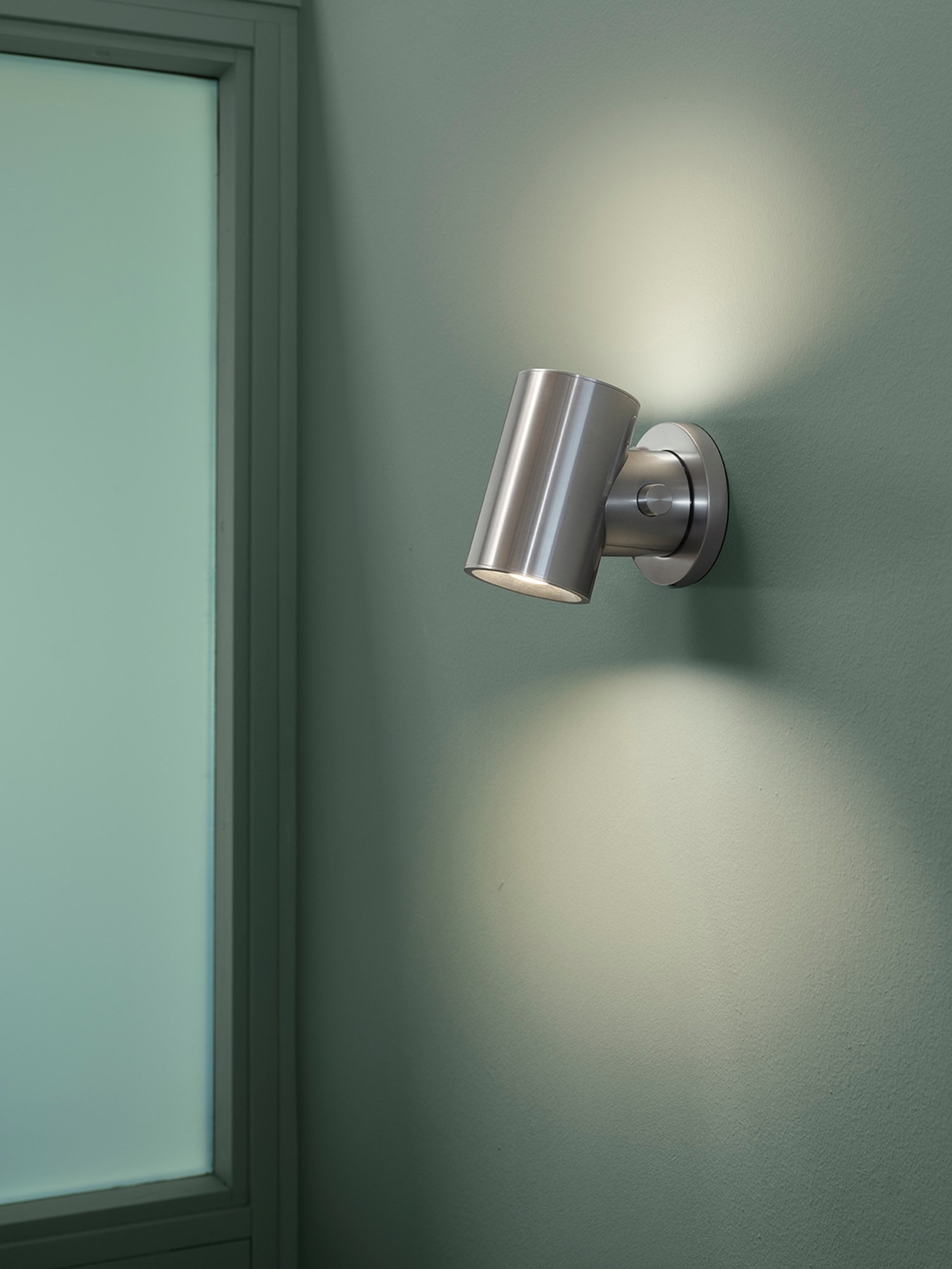 Beam Wall Lamp in polished aluminium casting a warm, comfortable light in a soft green room. Beam Wall Lamp in polished aluminium casting a warm, comfortable light in a soft green room.