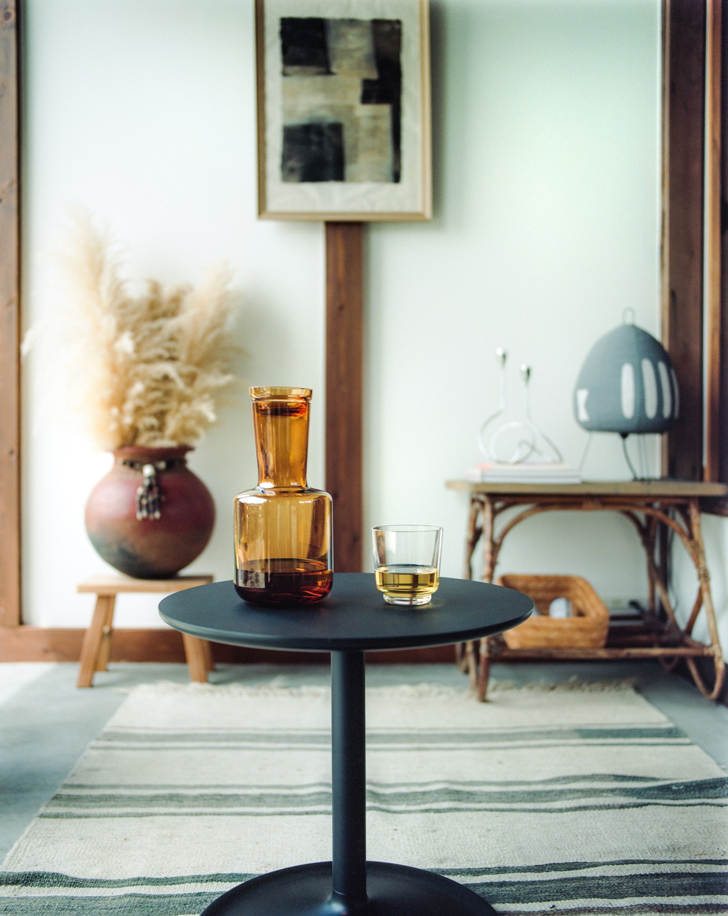 Modern side table with the Raise carafe and glass in a minimalist room. Modern side table with the Raise carafe and glass in a minimalist room.