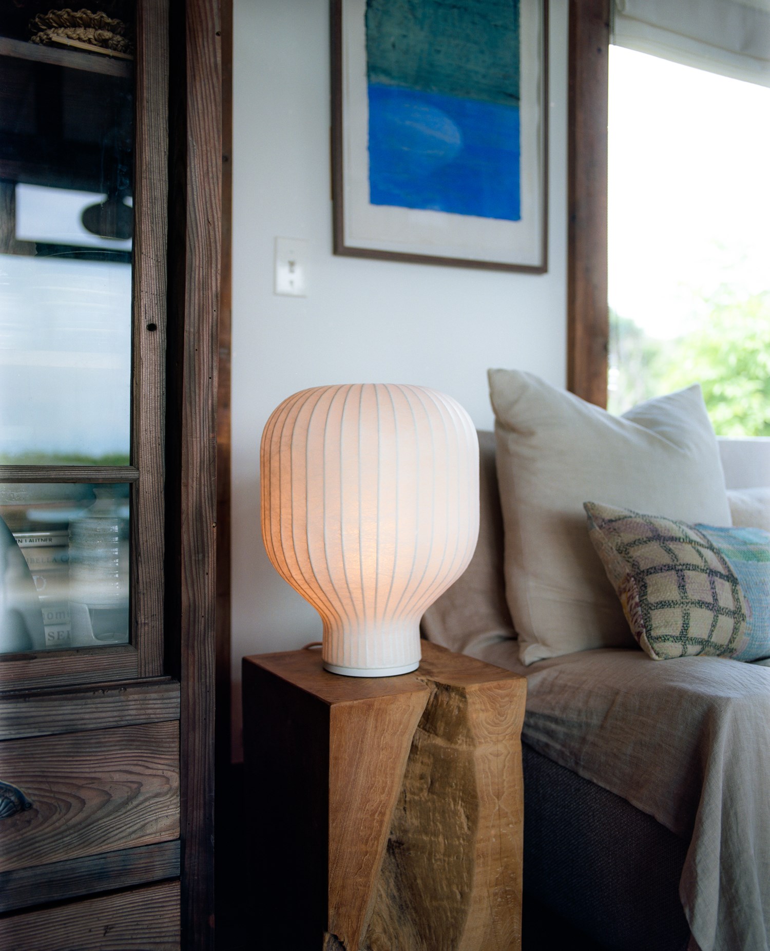 Illuminated Strand table lamp on a wooden block in a cozy interior. Illuminated Strand table lamp on a wooden block in a cozy interior.