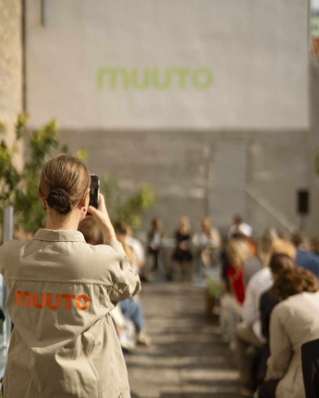 Speakers participating in a Muuto panel talk, seated on modern furniture in a modern outdoor setting.