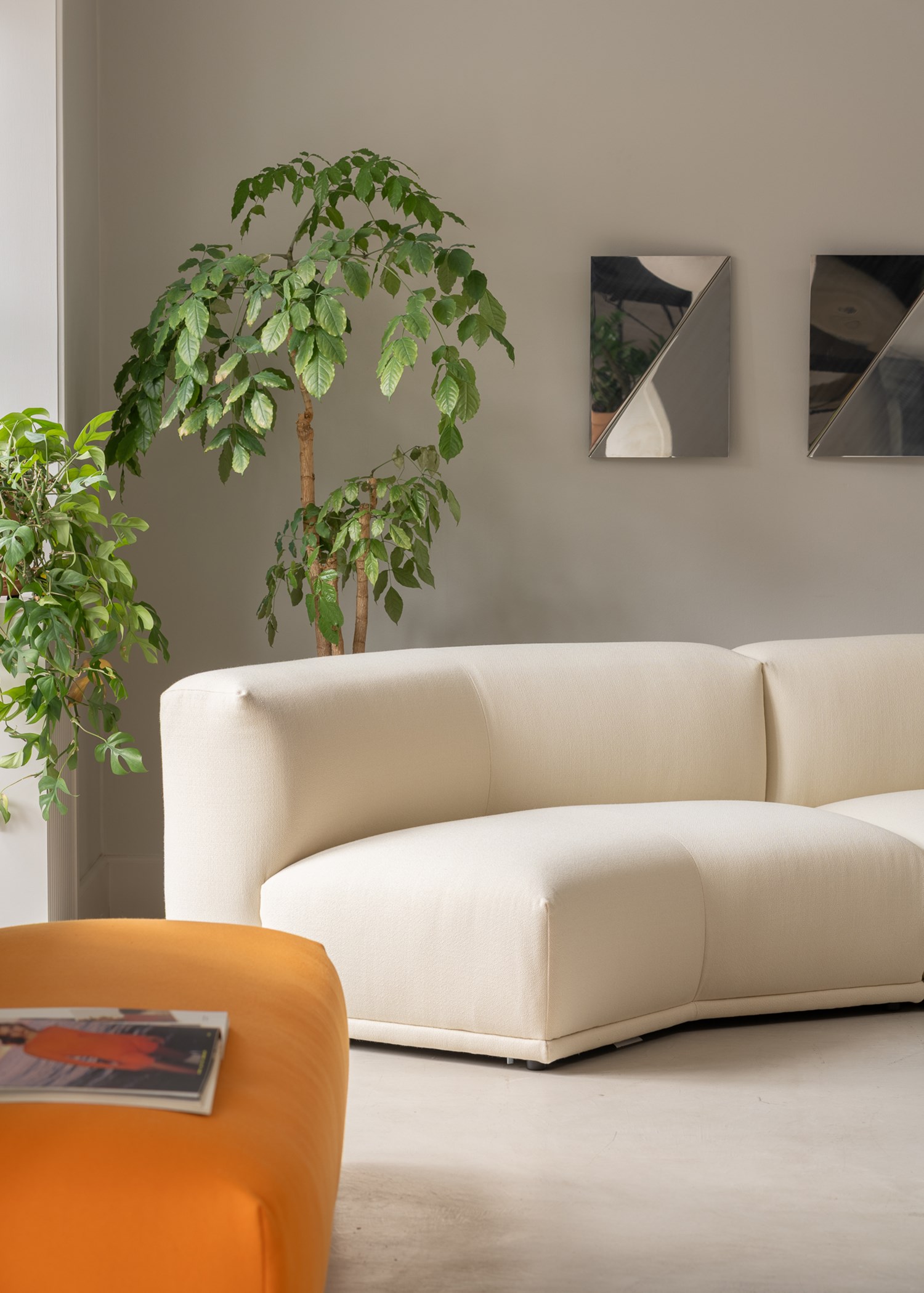 A white Connect sofa placed in a minimalist modern room, accented by artistic mirrors on the wall. A white Connect sofa placed in a minimalist modern room, accented by artistic mirrors on the wall.