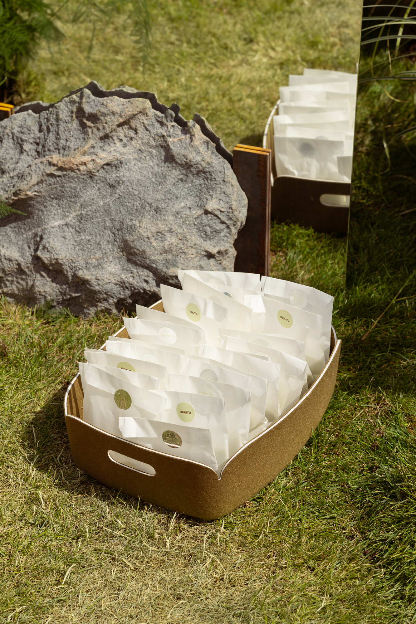 A green Restore basket with paper bags placed on the green glrass.