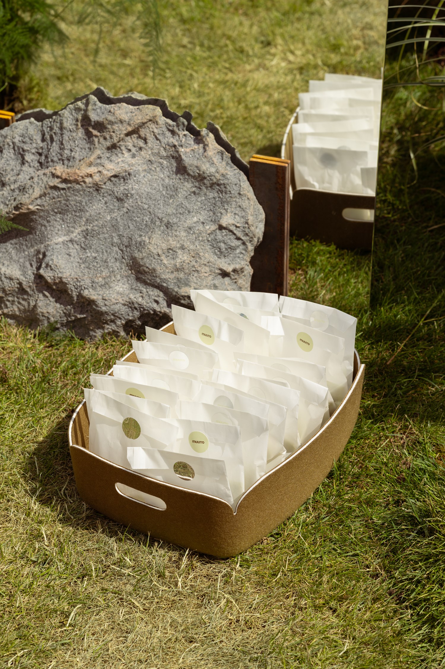 A green Restore basket with paper bags placed on the green glrass. A green Restore basket with paper bags placed on the green glrass.