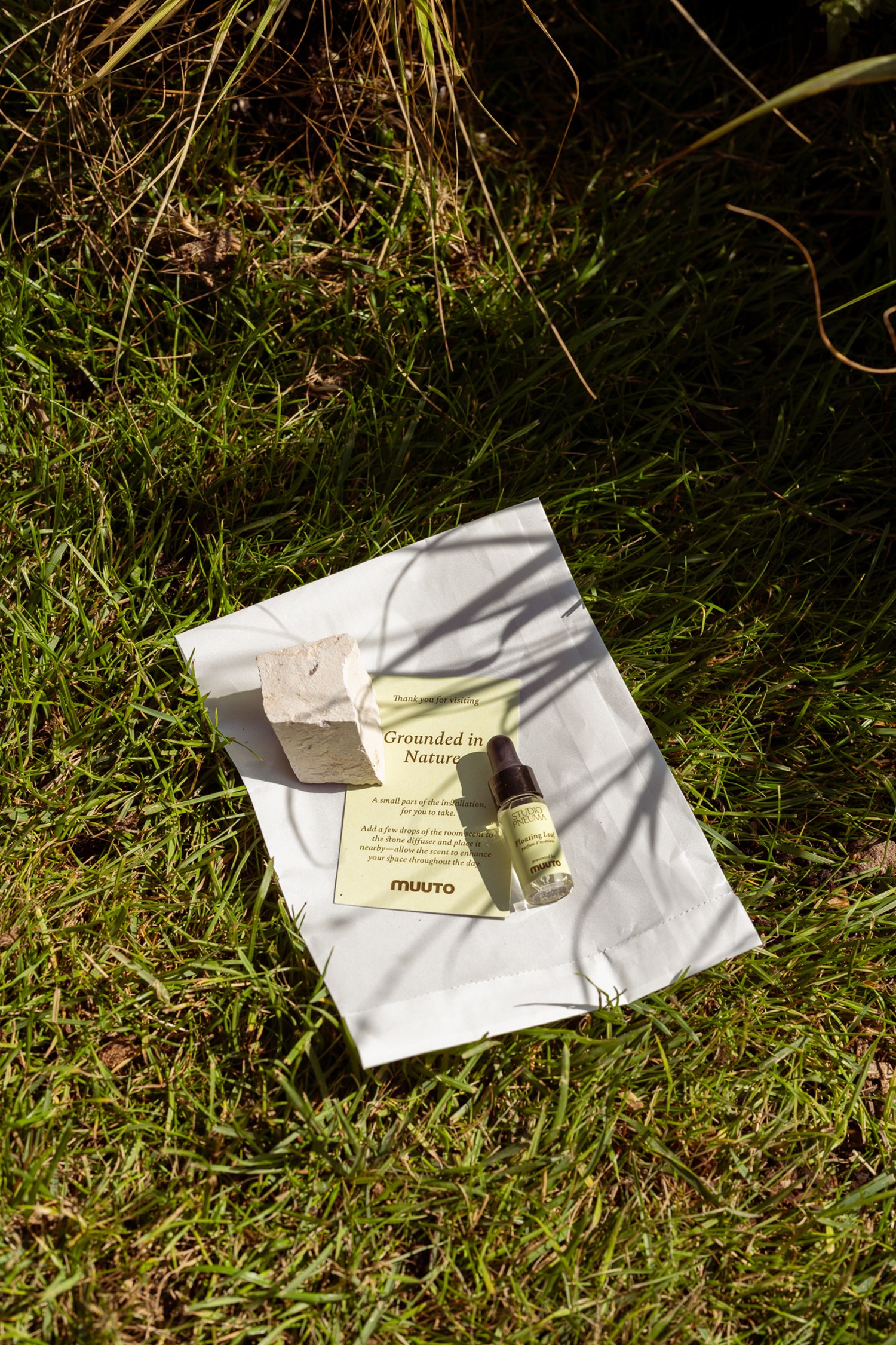 A small bottle with Muuto's own scent laying on the grass.  A small bottle with Muuto's own scent laying on the grass.