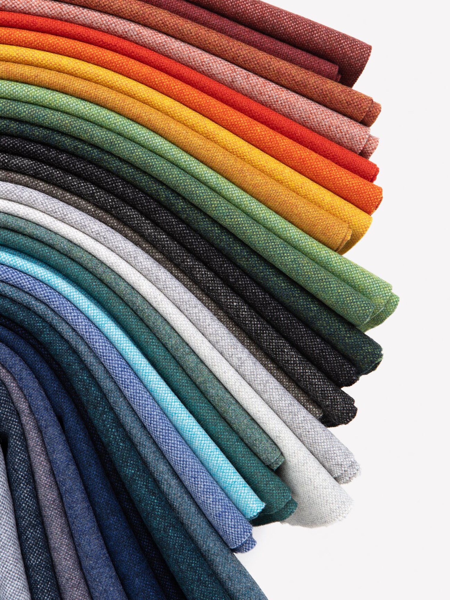 Colorful rolls of fabric arranged vertically, displaying a spectrum of colors with detailed textures. Colorful rolls of fabric arranged vertically, displaying a spectrum of colors with detailed textures.