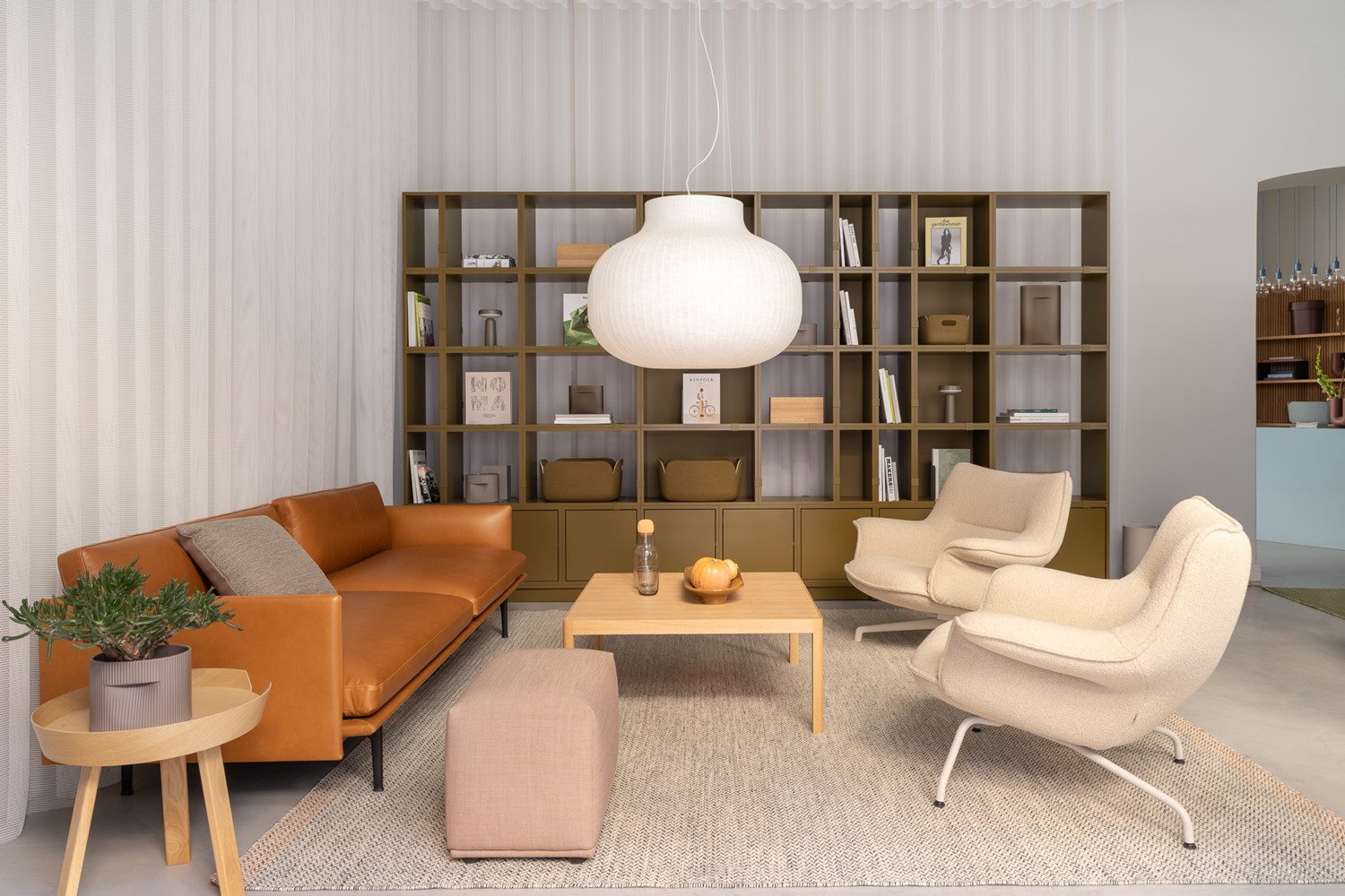 Stockholm Flagship Store - Scandinavian Living Room Design by Muuto Cozy living room setup at Muuto's Stockholm flagship store. Neutral tones, contemporary lighting, and a chic vase centerpiece complete the setting.