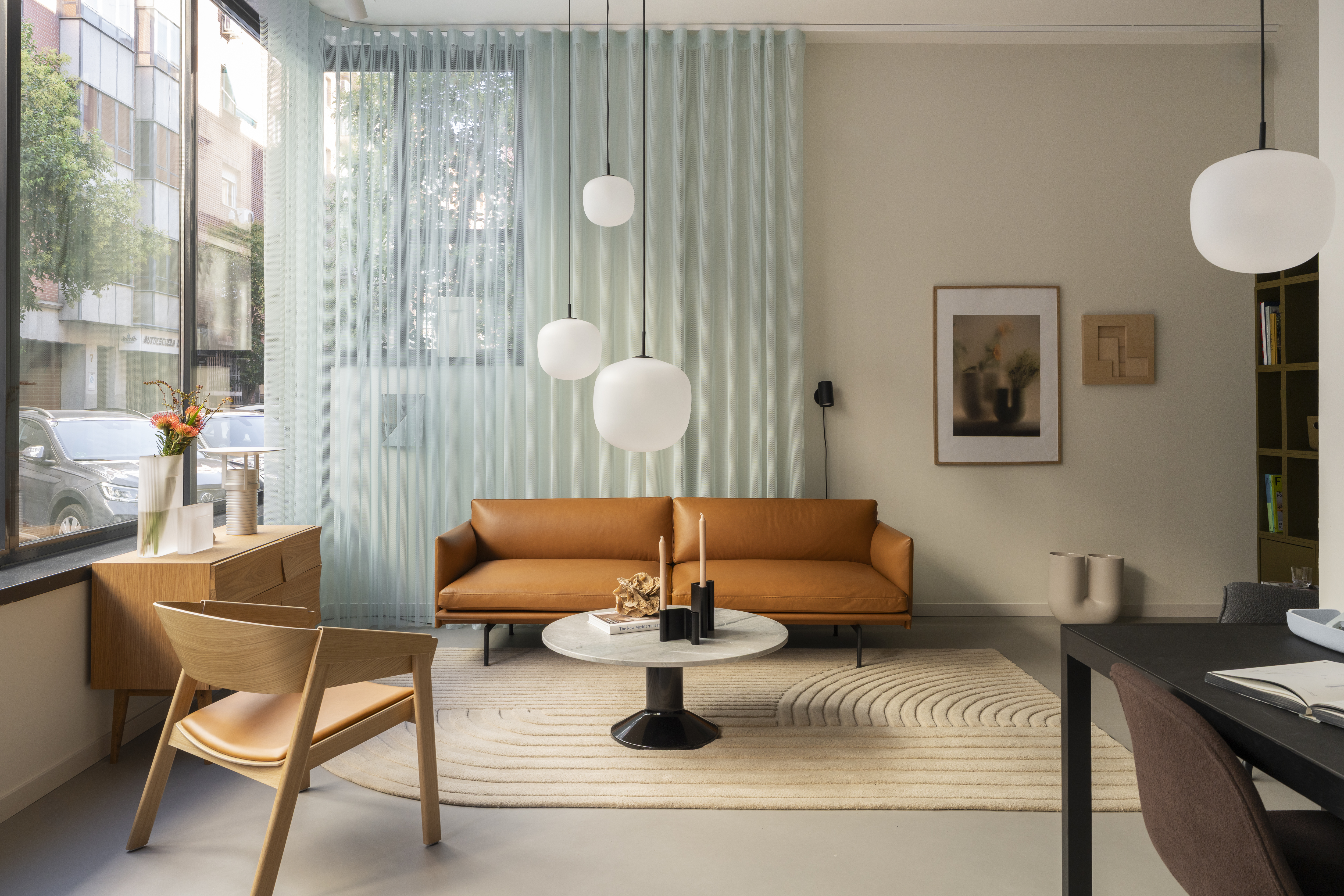 Interior view of the Muuto showroom in Madrid, showcasing contemporary furniture, lighting, and accessories arranged in a warm, minimalist setting.