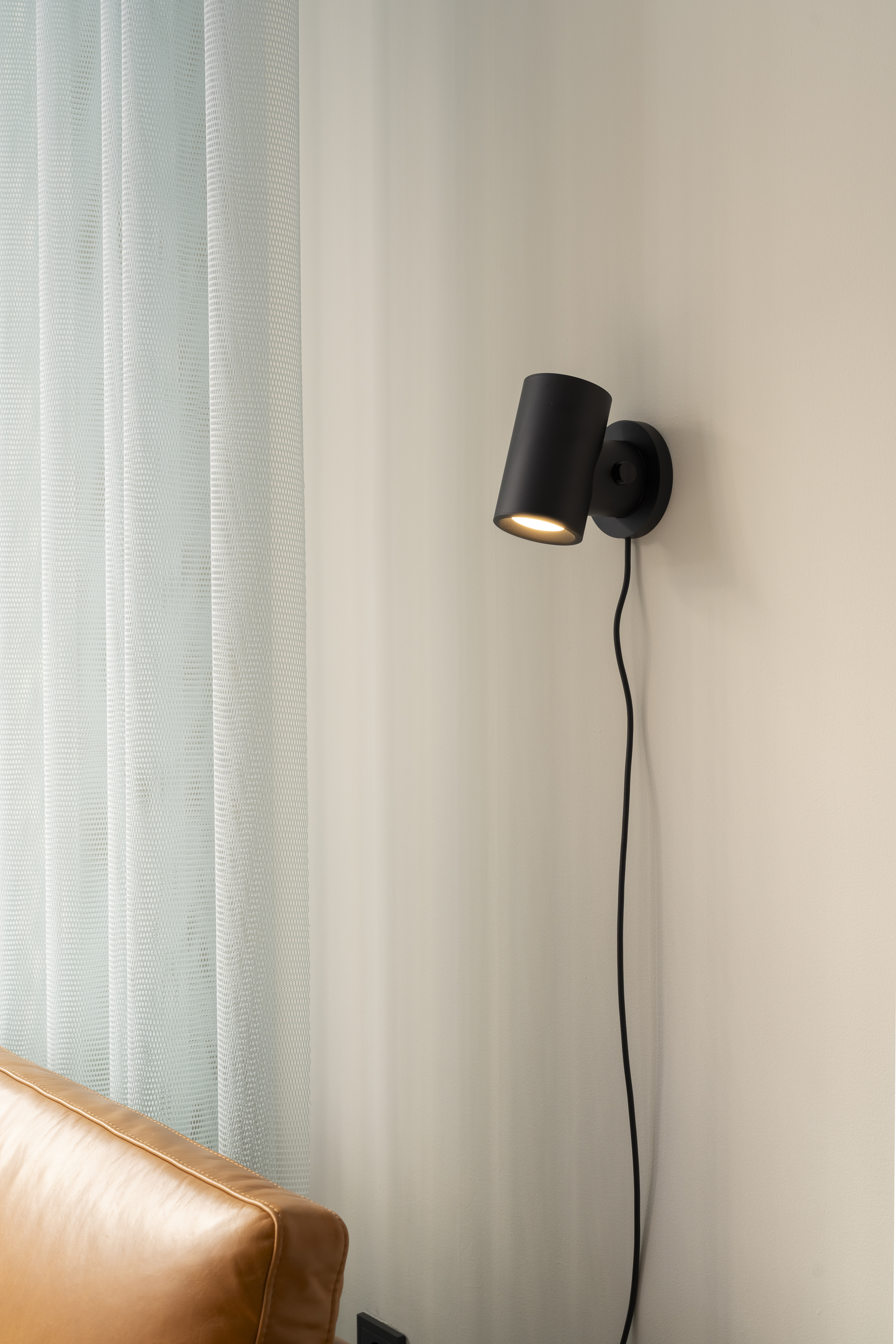 Interior from the Muuto showroom in Madrid featuring the Post Wall Lamp in black, styled in a clean and contemporary space with soft tones and modern furnishings.