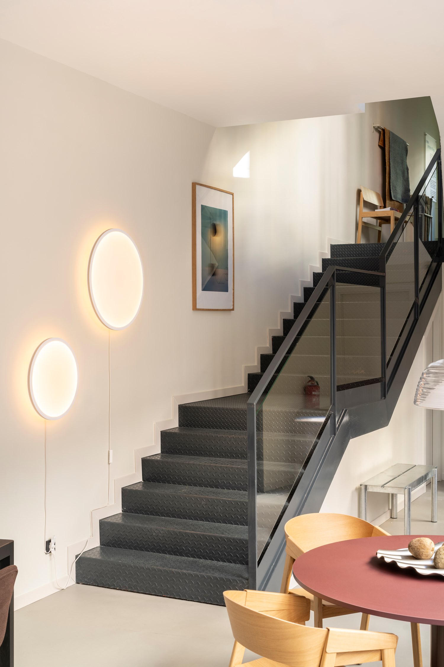 Staircase area from the Muuto showroom in Madrid featuring the Calm Wall Lamp, styled in a clean architectural space with soft light and modern details. Staircase area from the Muuto showroom in Madrid featuring the Calm Wall Lamp, styled in a clean architectural space with soft light and modern details.